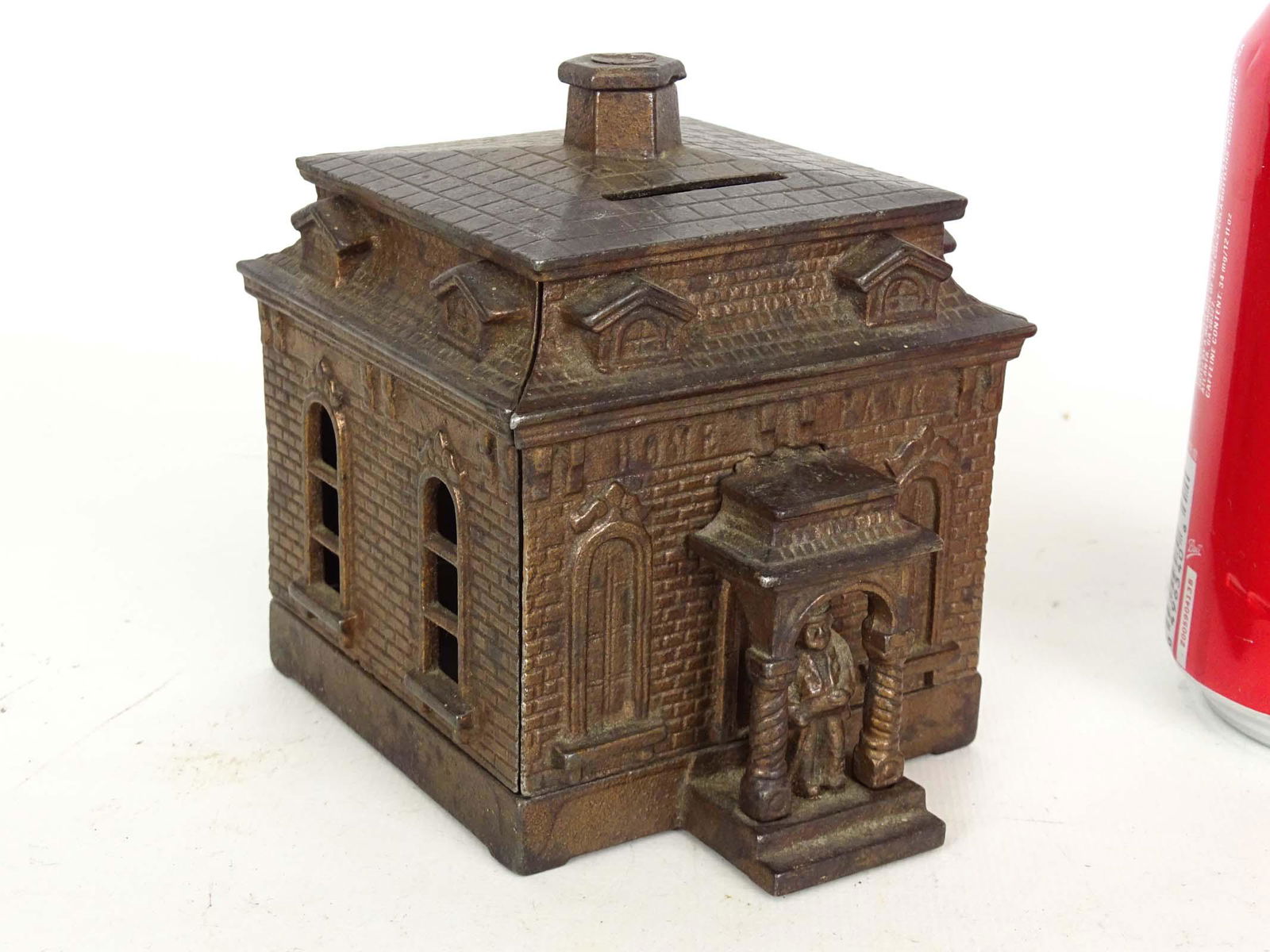 Bank: Judd MFG. Co. "Home-Bank". C. 1895. Note figure in door. 3 1/2" x 4" x 4 1/2".