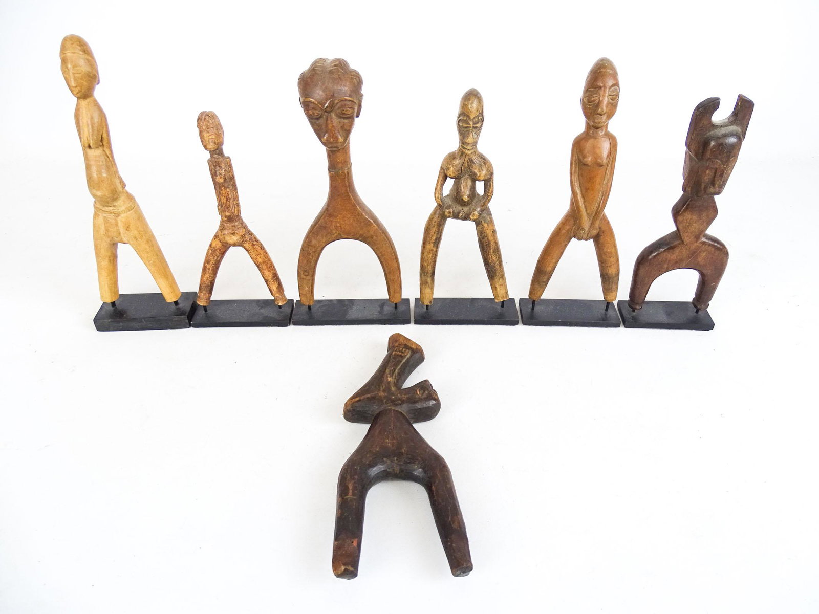 Baule African Slingshots: (7) wooden Baule African slingshots. All on stands except one. Tallest 9 1/2" Ht..