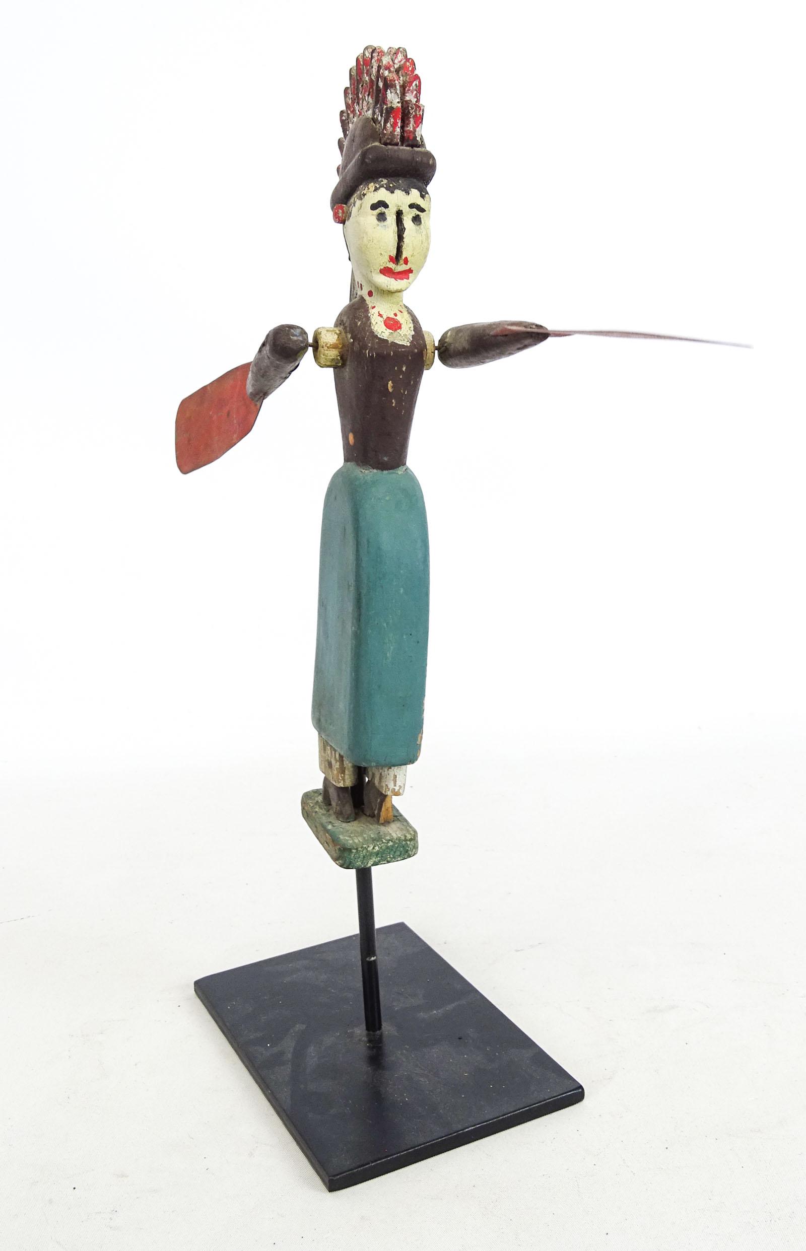 Whirligig: C. 1900 hardwood whirligig, woman with tin paddles. Old paint surface. 12" Ht.. Stand included, 15" overall Ht. on stand.
