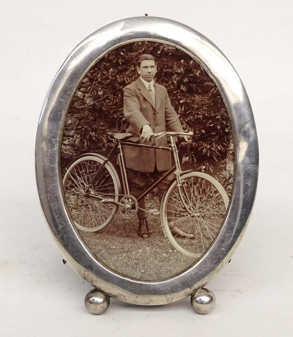 Bicycle Photograph in Sterling Silver Frame: Sterling Silver frame with an Edwardian Cyclist - Oval footed frame is hallmarked STERLING and weighs 33 grams. 6-1/4Â” x 4-5/8Â” with a ½Â” rim. Photo is of a gentleman posing with wh