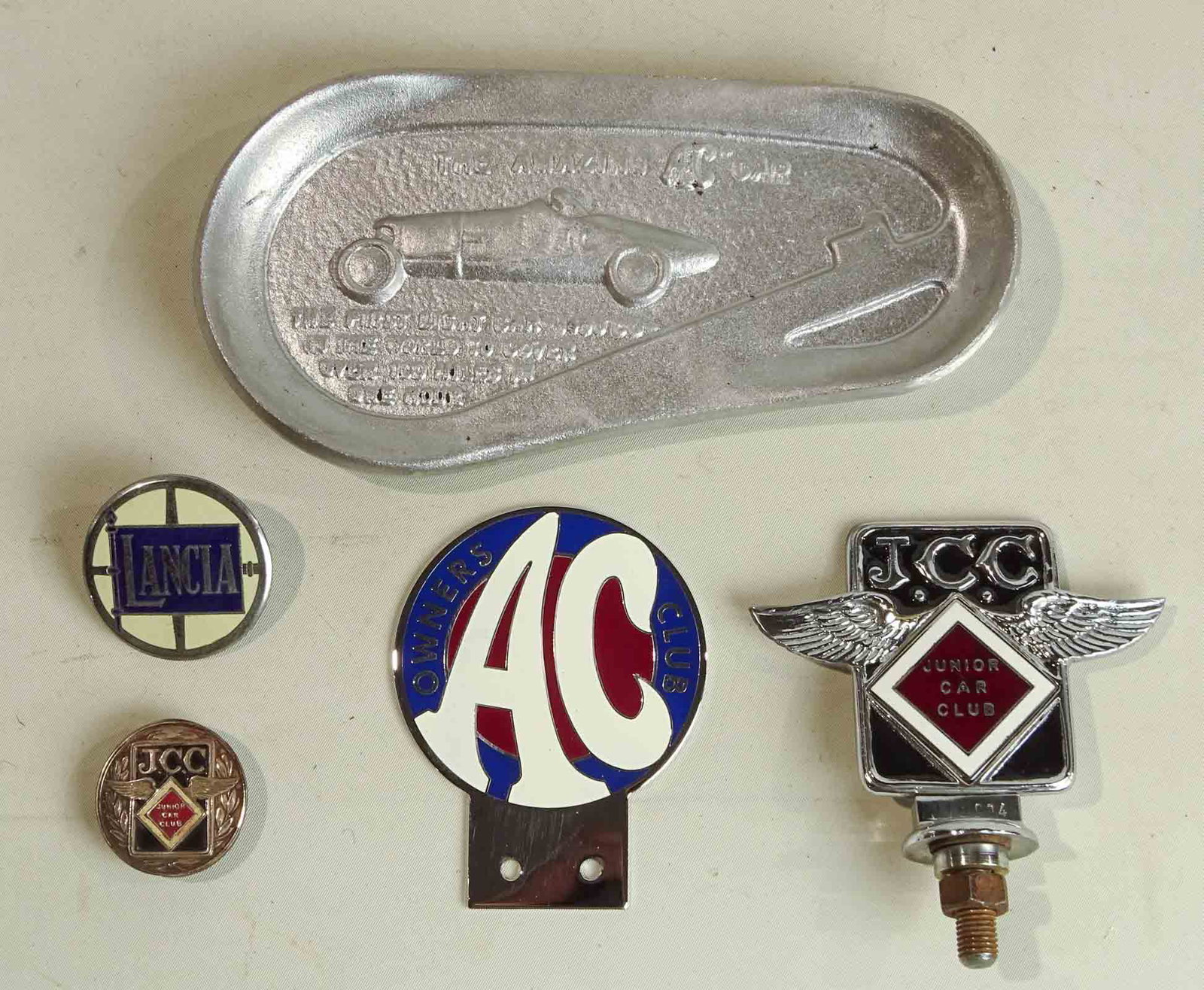Misc. Lot: Lot including AC, Lanlia, Junior Car club badges and AC commemorative ashtray. Good condition.