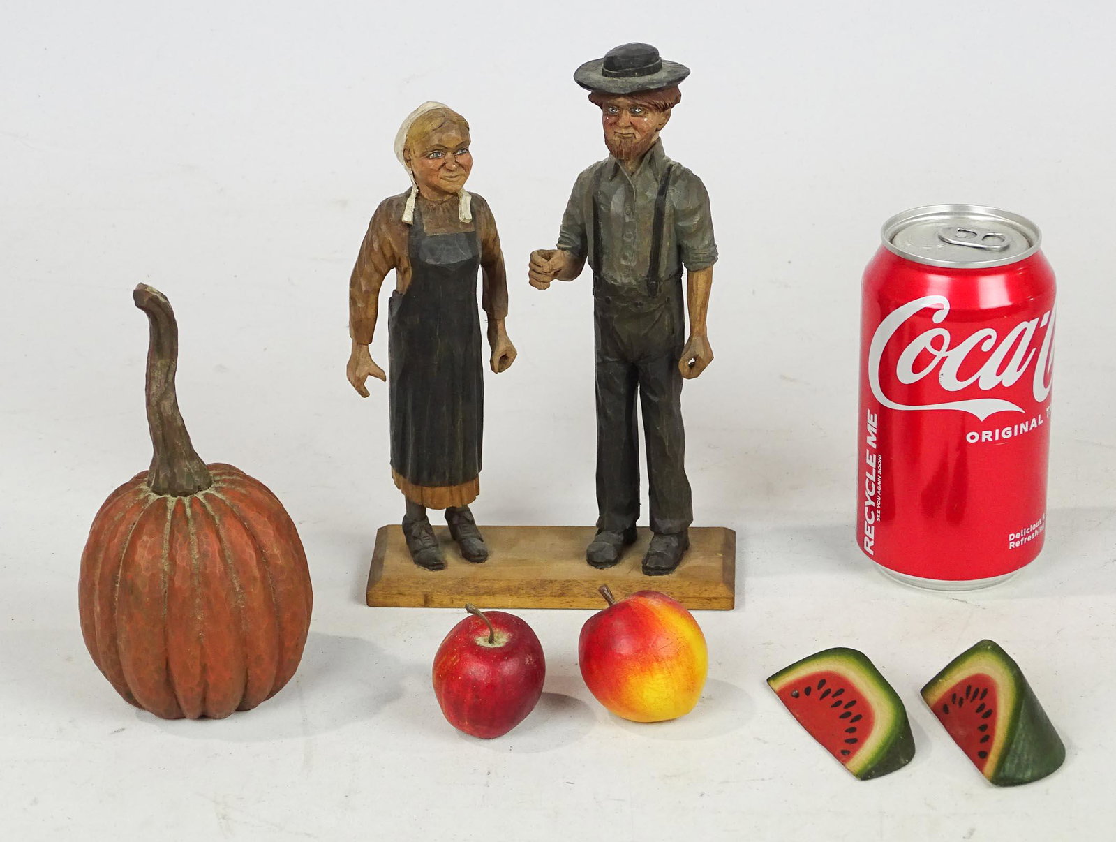 Misc. Lot: Lot including carved wooden Amish couple marked Shoemaker (8" Ht.) and (5) pieces of carved wooden fruit.