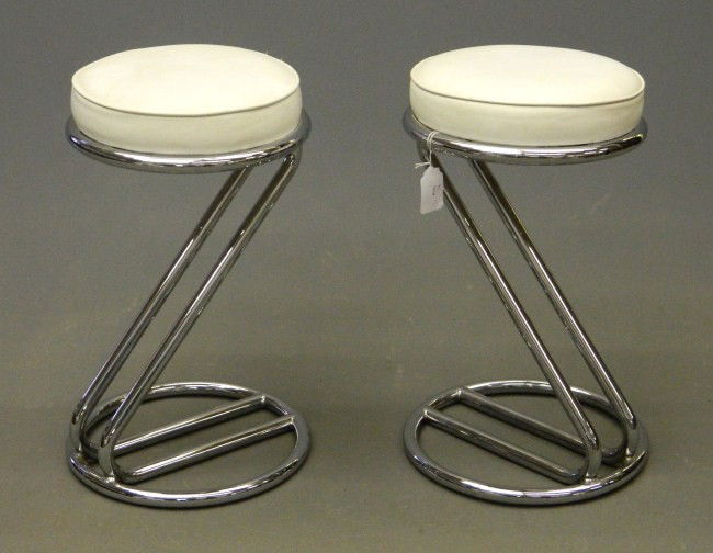 Mid Century "Z" Stools: Pair "Z" stools attributed to Gilbert Rohde. White leather and chrome. 25" Ht. Each. Rohde was a prominent industrial designer for Herman Miller and other companies in the 1930's-50's.