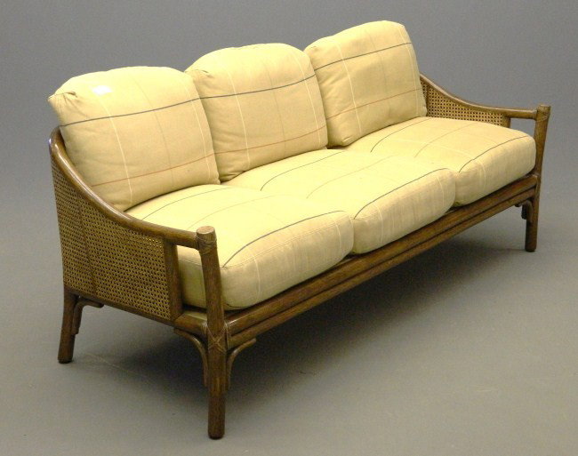 Rattan Sofa: Vintage rattan sofa with cushions. 72' W.