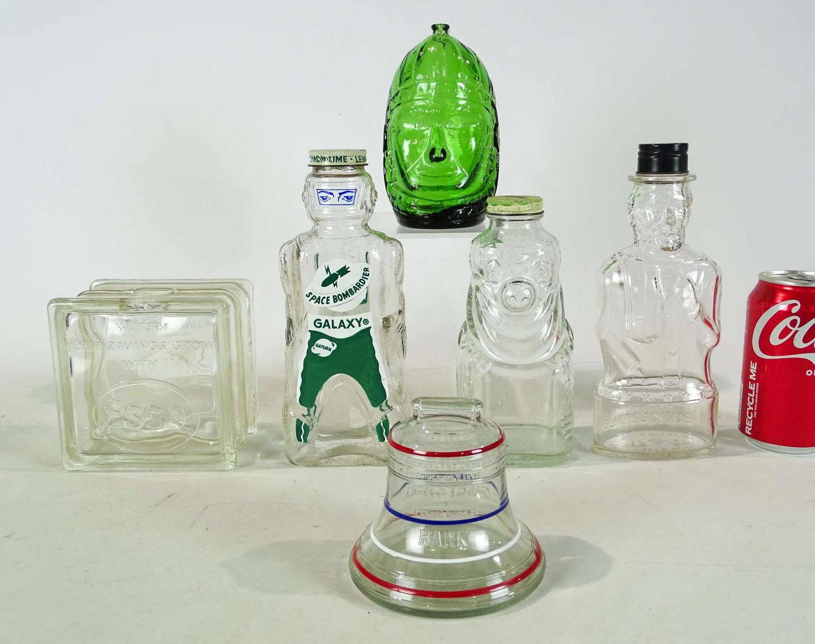 Bank Lot: Lot (6) early glass banks including "GALAXY / SPACE BOMBARDIER", Lincoln, American Indian Chief, Liberty Bell, Esso (coin hole rougn), etc..