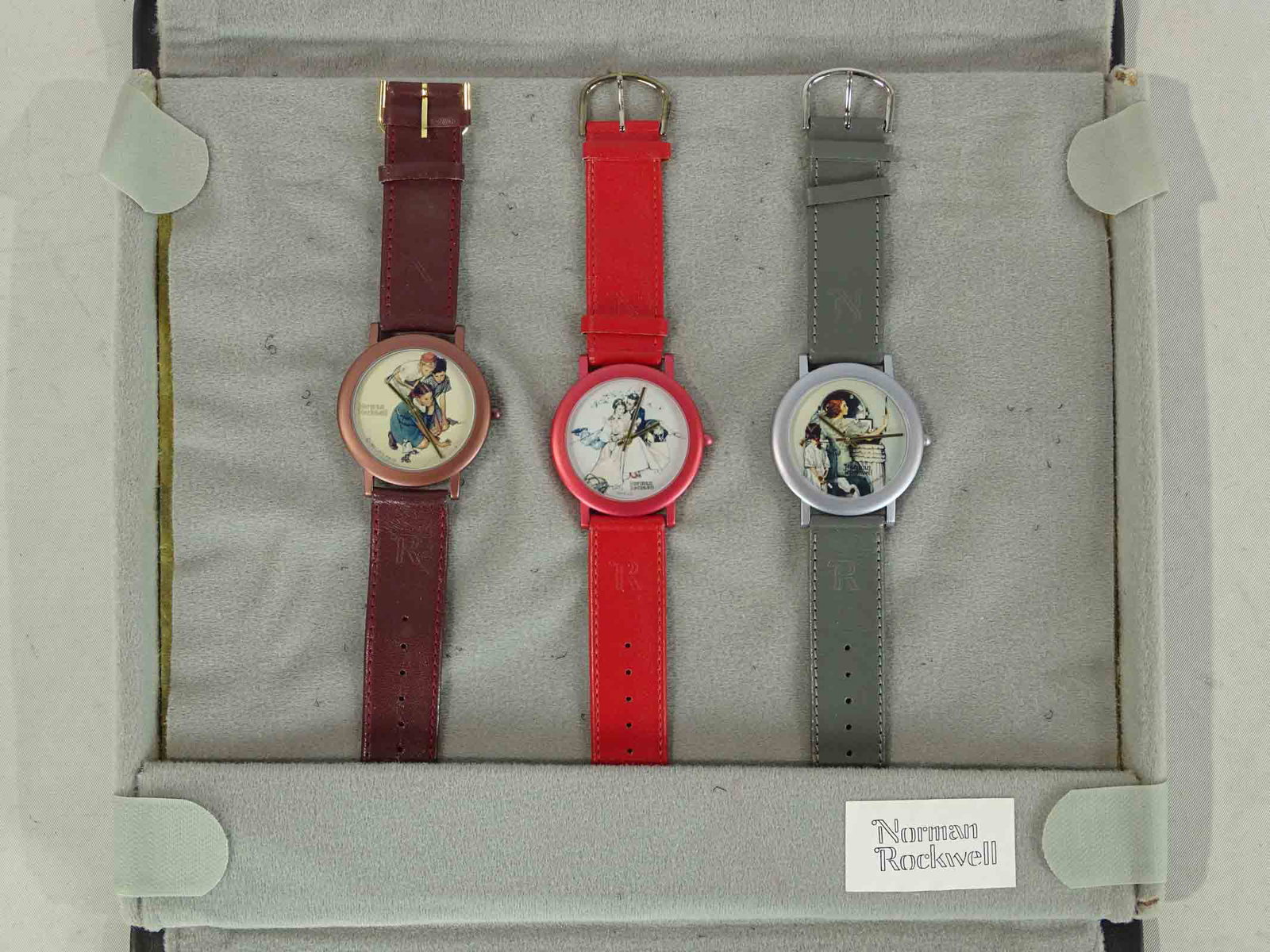 Norman Rockwell Wristwatches (3): Group of 3 wristwatches in original salesman's folding soft case, each with a different Rockwell illustration art on the face. Not tested, but apparently unused. Some velcro on backsides. Made by Clas