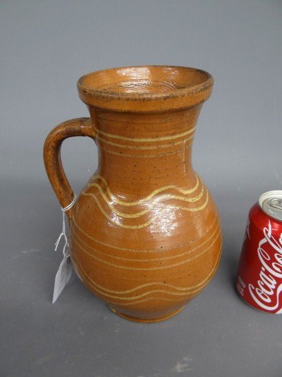 Redware Pitcher: Redware slip decorated pitcher. 9 1/2" Ht.