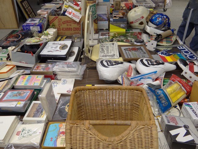 Bicycle Collectible Lot: Misc. table lot of collectibles including: rubber stamps, print blocks, plaques, mirrors, banner, dealer pens, toilet seat!, saddles, parts, games, stamps, greeting cards, toys, pins, posters, music b