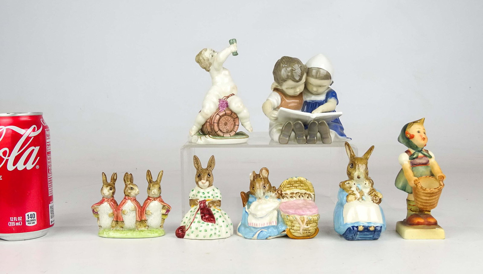 Porcelain Lot: Lot including Hummel figurine, Danish figurine, early figurine figure on wine barrel, Beswick, Royal Doulton figurines (one with cradle has ear chip).
