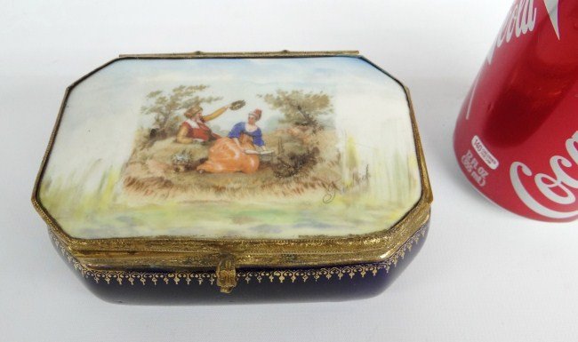 19th c. German Porcelain Box: 19th c. German porcelain hand painted box, lid signed "Friedrick". Brass surround loose from box but intact, interior mirror cracked. 5' W 3 1/2" D 2 1/4" Ht.