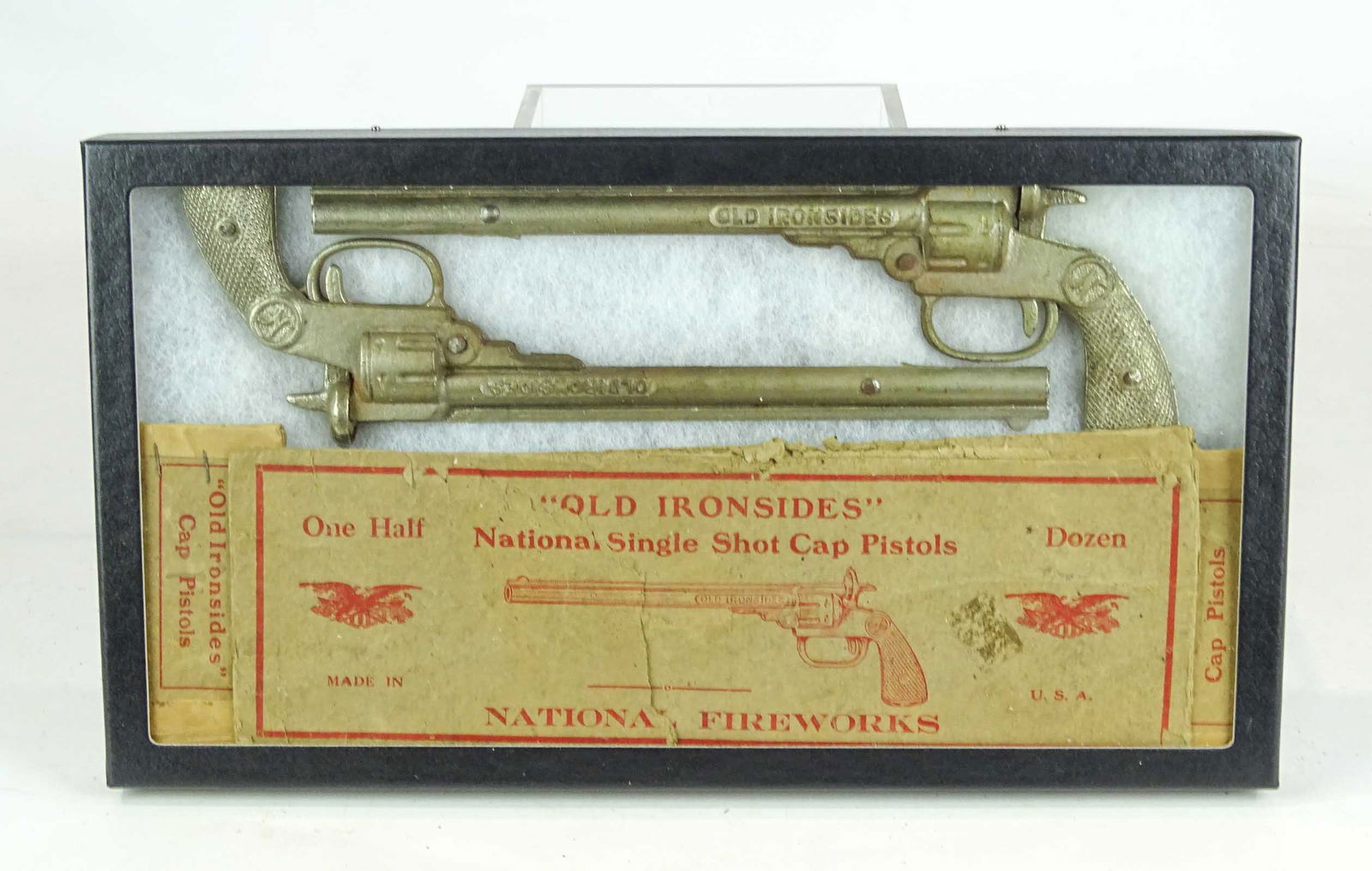 Cap Guns: Lot (2) National Fireworks "OLD IRONSIDES" cap pistols. Original as found box included. Display case included. 10 3/3" L..