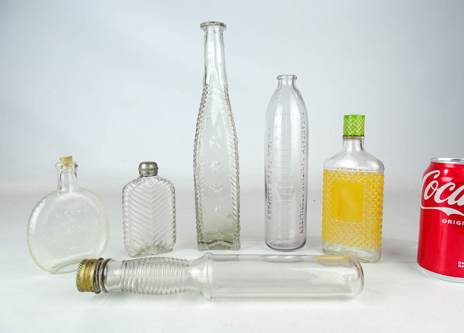 Lot of Bottles: Lot (6) early bottles and flasks. One marked "Merry Christmas And Happy New Year", WHITALL TATUM COMPANY, candy container and more. Tallest 11" Ht.. Good condition.