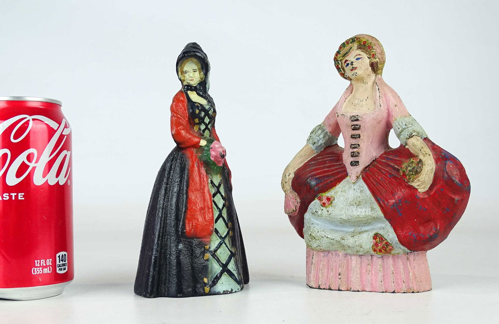 Doorstop Lot: Lot (2) cast iron doorstops including: "Little Southern Belle" (cast iron, 6 5/8" Ht., MFG. National Foundry), "Women in Hoop Skirt" (cast iron, 6 5/8" Ht., Albany Foundry).