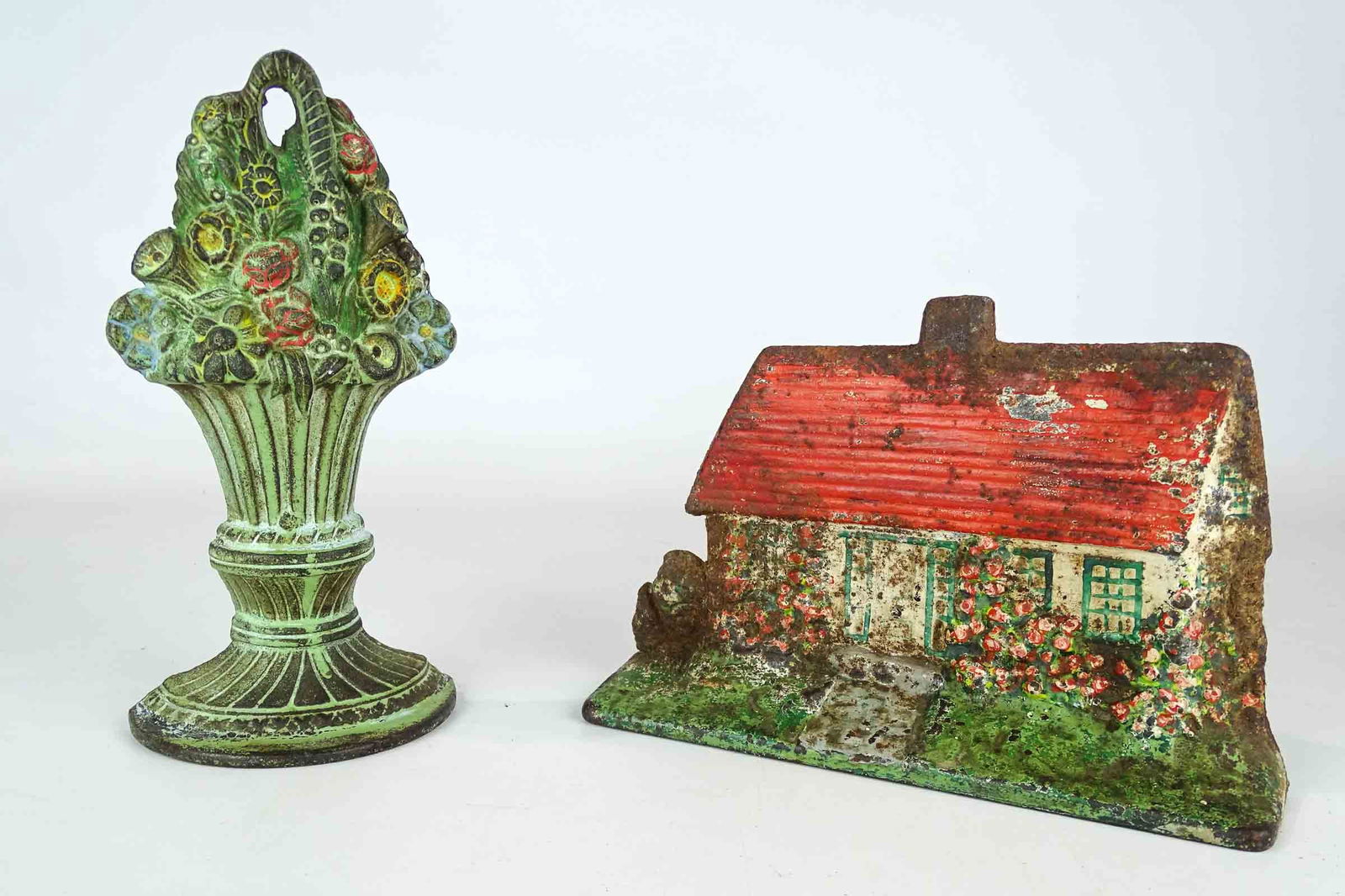 Doorstop Lot: Lot (2) doorstops including: "Cottage with Hollyhocks" (cast iron, 6" Ht., Albany Foundry), and "Mixed Flower Basket" (cast iron, 8 5/8" Ht.).
