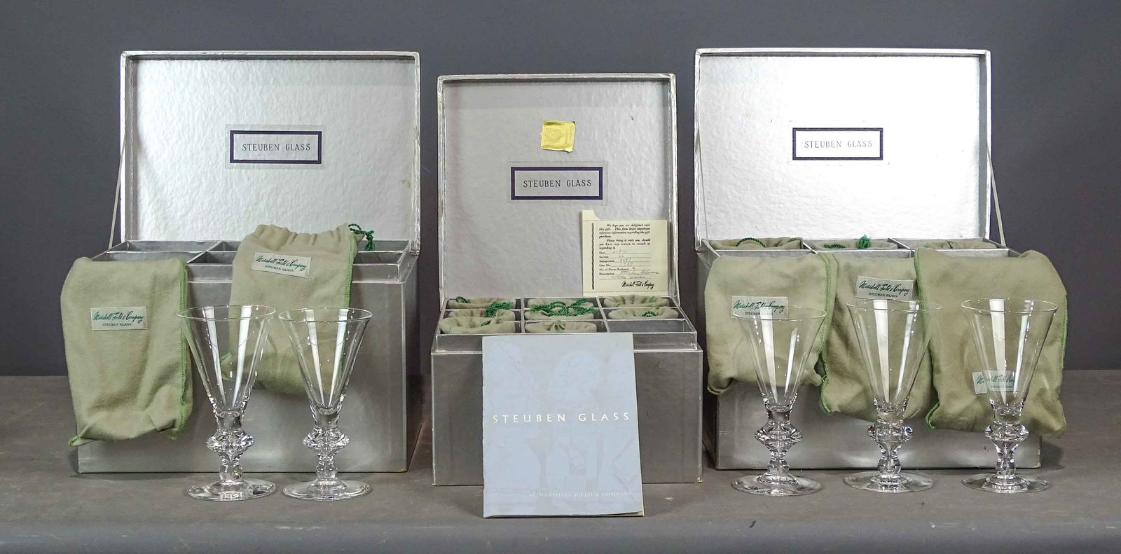 Steuben Glass Lot: Steuben glass from Marshall Fields & Co., Chicago 1955, wine trumpets design T-3 (8), large and (8) small in original cloth bags, boxes and paperwork.