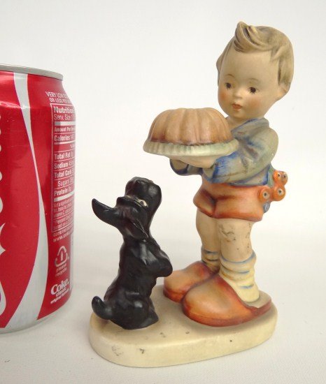 Hummel Figurine: Boy with cake and flowers and dog MJ Hummel figurine. Marked Germany. 6" Ht. Full bee.
