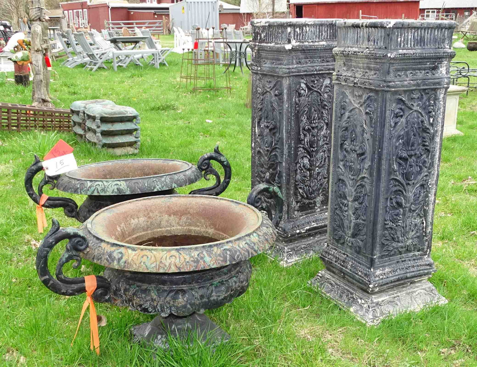 Pair of Cast Iron Urns: Pair of cast iron urns on cast cement plinths. 22" Dia. x 50" Ht.. Barbara Packer Collection.