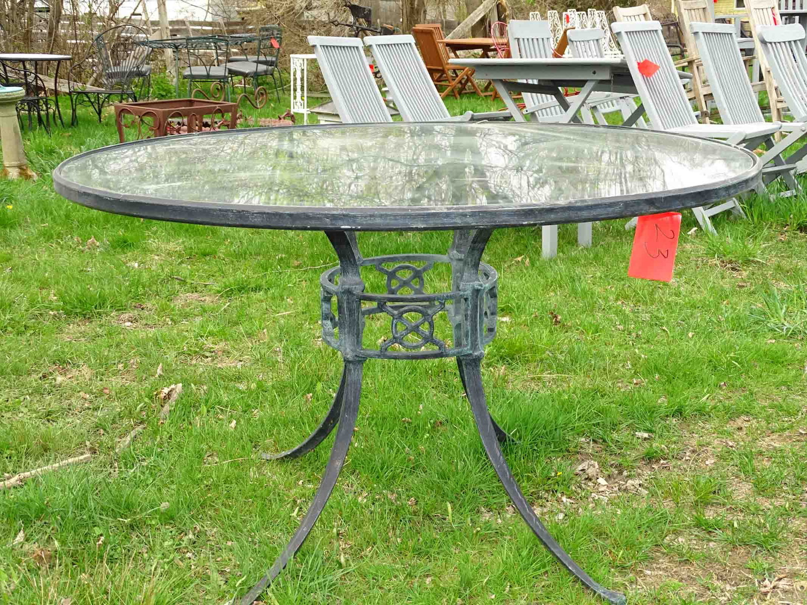 Woodard Metal Table: Woodard metal patio table with glass top. 48:" Dia. x 28" Ht.. Barbara Packer Collection.