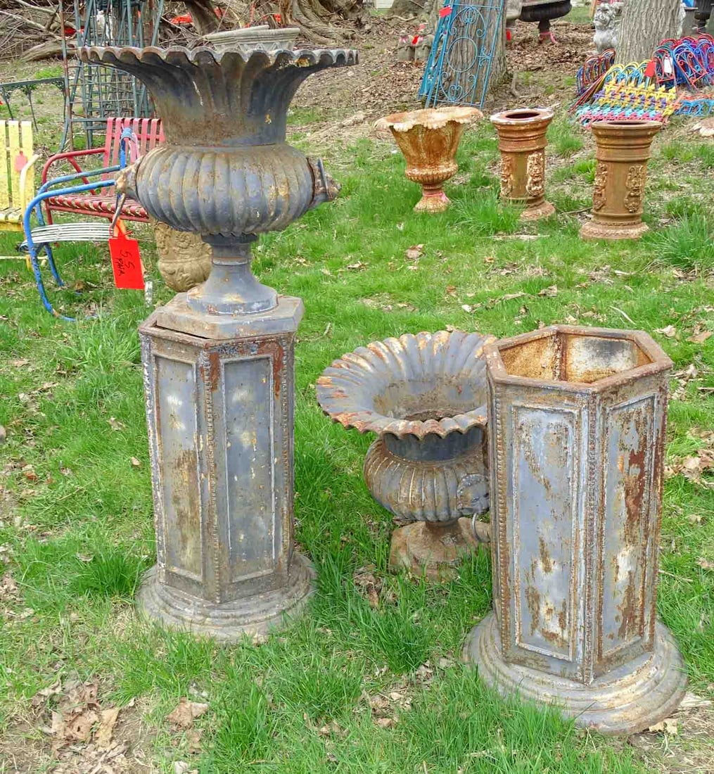 Pair of Urns: Pair of cast iron urns on hexagonal bases. 46" Ht.. Barbara Packer Collection.