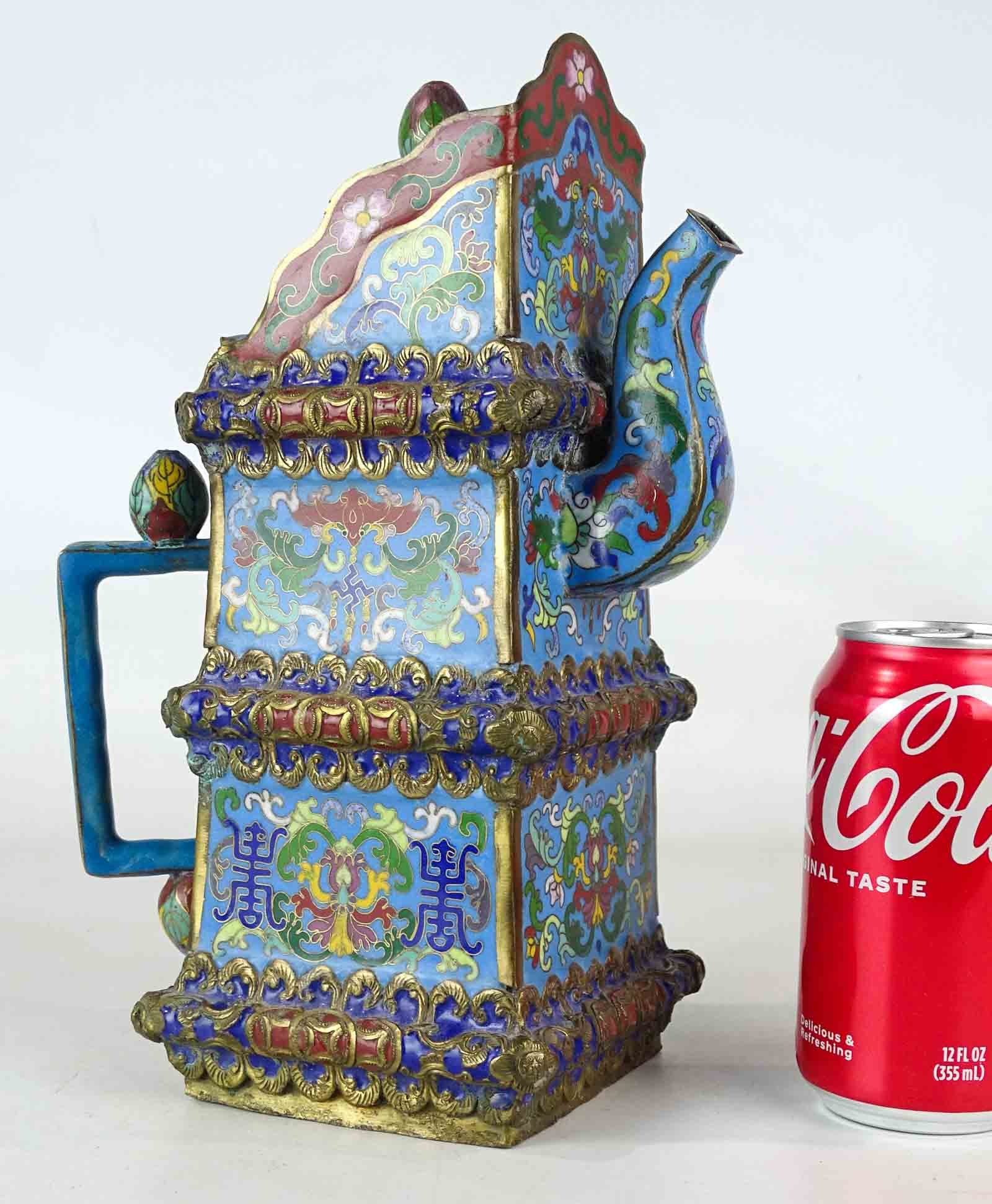 Asian Cloisonne Pitcher: An Asian pitcher with lid, decorated in colors and patterns with cloisonne enamel. Handle reattached.11" Ht..
