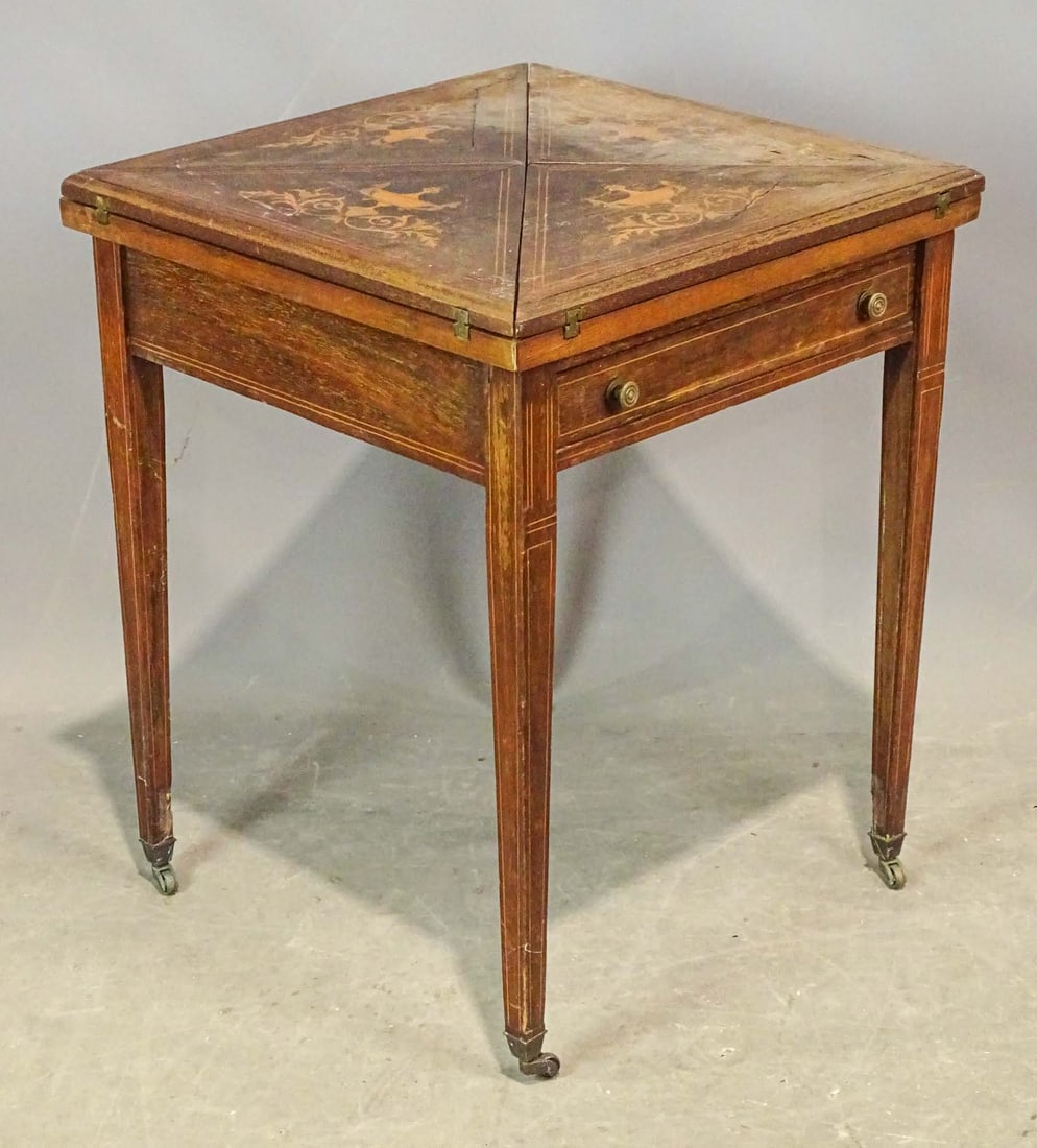 Inlaid Game Table: Early inlaid handkerchief game table. Feet raised on casters. 20" x 20 1/2" x 25 1/2" Ht..