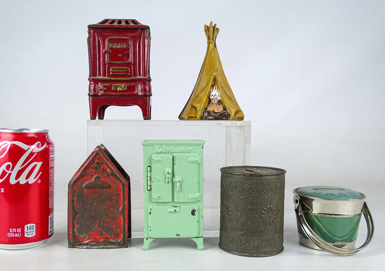 Bank Lot: Lot (6) banks inluding teepee, Kelvinator (missing rear foot), stove, tin, tin building. Tallest 4 1/2" Ht..