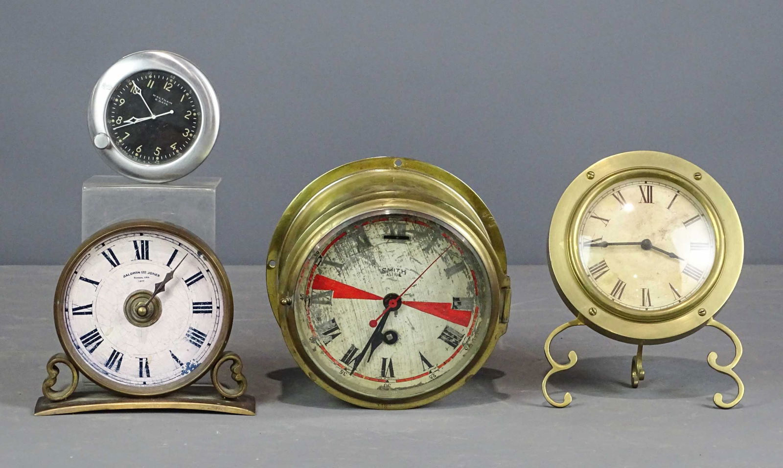 Clock Lot: Lot (4) clocks including "Smith Astral", brass (7" D., 3 1/4" D.), Made in India brass shelf on scrolled legs, 7" Ht., 5 3/4" D.), "Baldwin and Jones…Boston USA 1812", Mfg. "Timeworks Inc. Berkley C