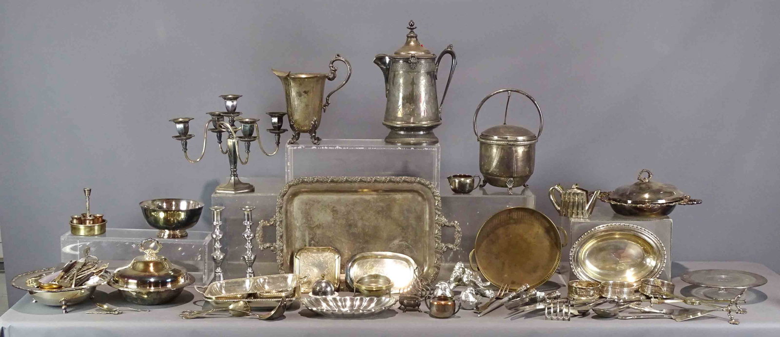 Silverplate Lot: Misc. silverplate lot including ice buckets, platters, napkin holders, covered dishes, candelabra, cold water pitcher, figural birds, wine caddies, misc. flatware. Approx. 60 pieces. Provenance: The E