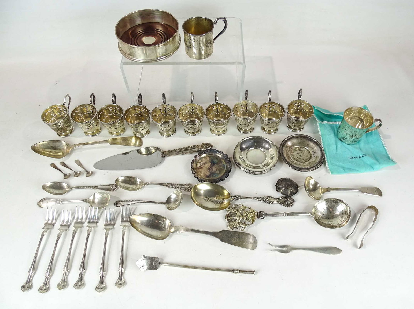 Sterling Silver Lot: Misc. sterling silver lot including (24) pieces flatware, wine caddy, (7) 3 1/2" saucers, (10) open cups, (6) 3" saucers. Approx. 1555 grams.