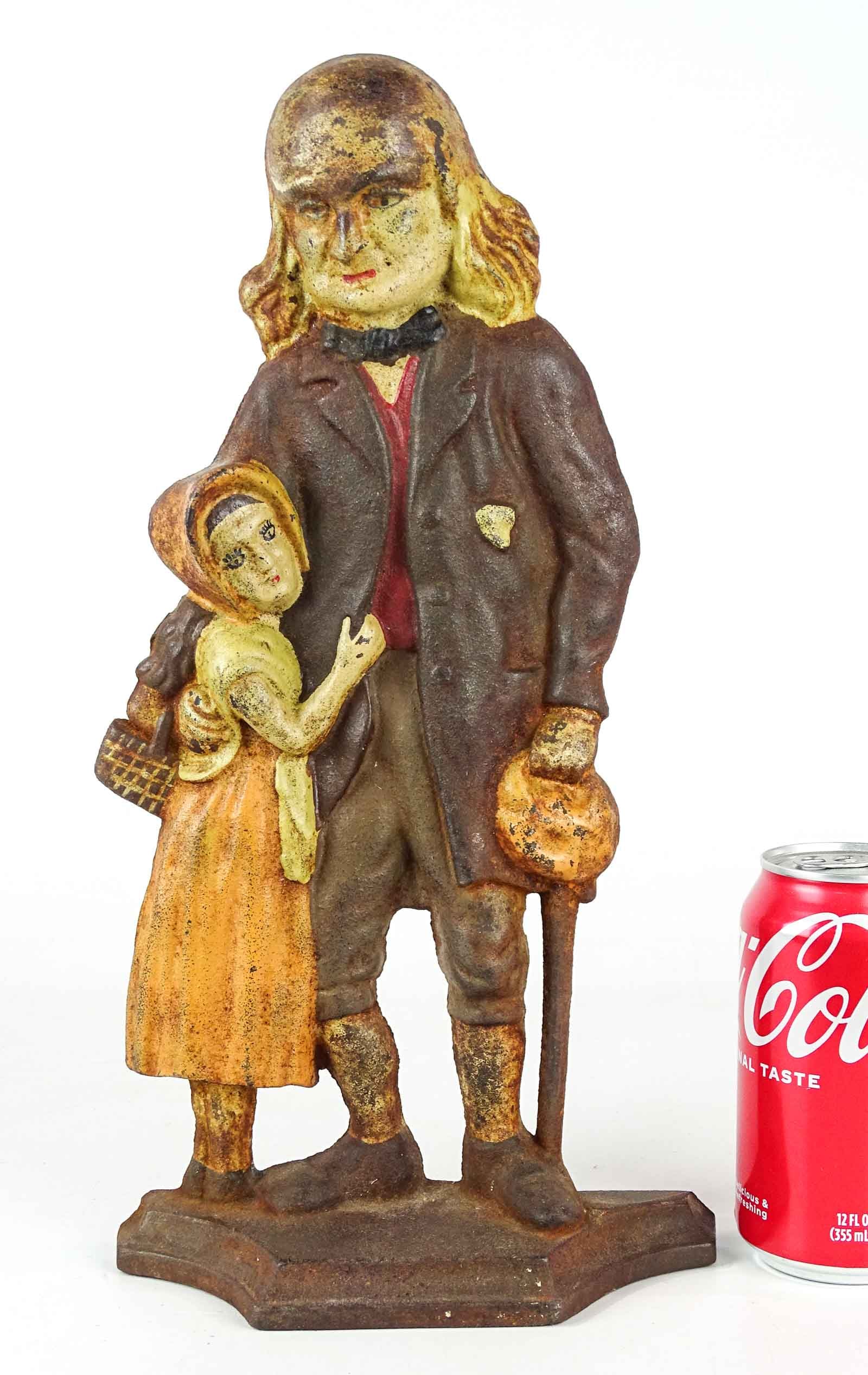 Doorstop: Cast iron "Old Man with Grandchild" doorstop. Marked "C.N.". 14 1/4" Ht..