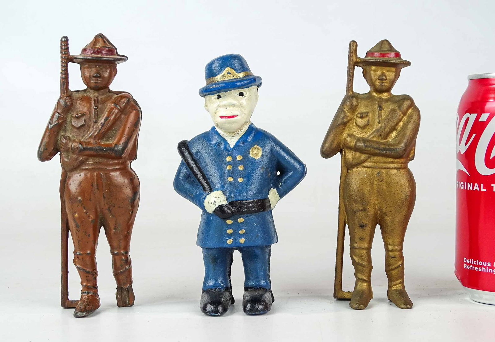 Boy Scout Banks: Lot (2) cast iron Boy Scout banks. 6" Ht.. One missing partial right foot. Along with Policeman.