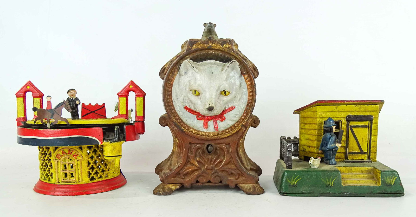 Mechanical Bank Lot: Lot (3) mechanical banks including log cabin with policeman (Book of Knowledge), circus, horse trotting.