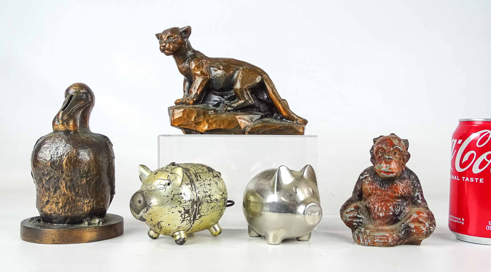 Bank Lot: Lot (5) cast metal banks including Pelican, Lion, Monkey, (2) pigs. Tallest 7" Ht..