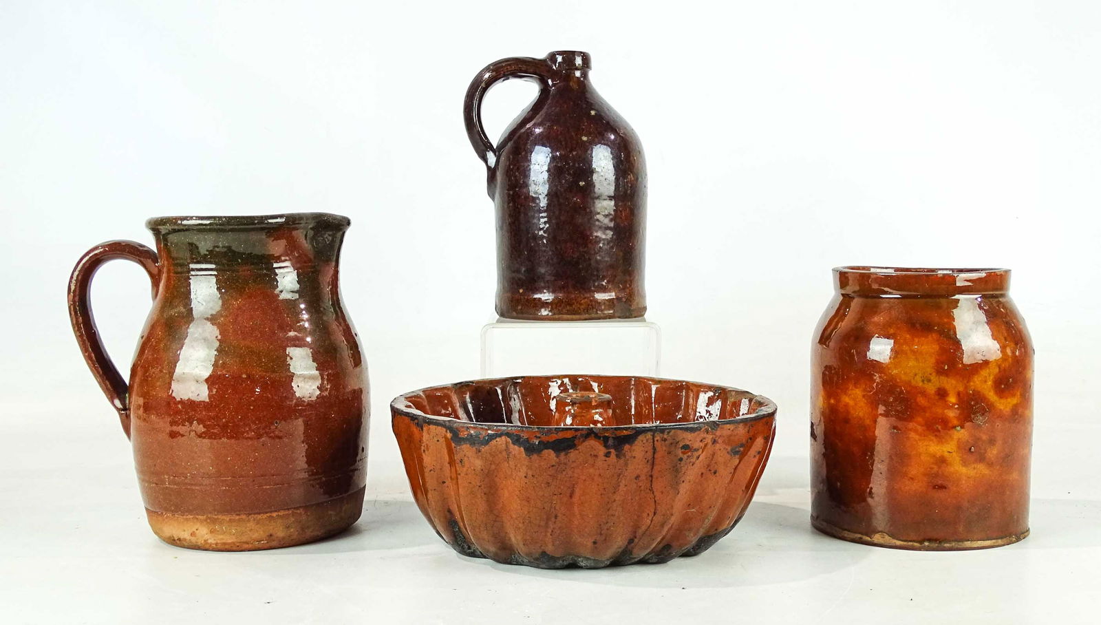 Redware Lot: Lot (4) pieces of redware including Turks head mold (9 1/2" D.), jug, jar, pitcher (tallest 8" Ht.). Provenance: Ed and Anita Holden Collection.