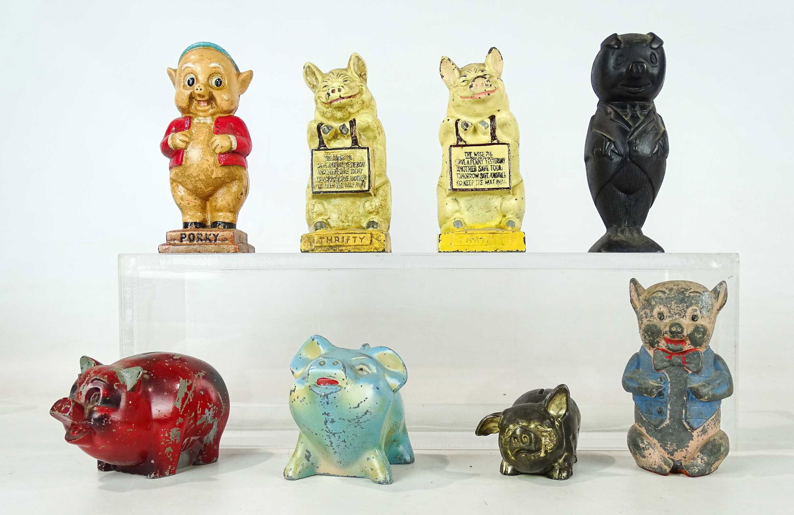 Bank Lot: Pig still bank lot including "Porky", (2) Thrifty, pig in suit, (4) pot metal examples. (8) pieces.