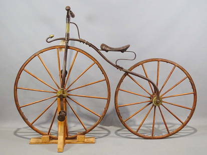 19th c. Boneshaker Bicycle: 19th c. Blacksmith made iron, wood and brass Boneshaker bicycle. 35" front wheel, 31" rear wheel. Acorn finial in front. Good condition.