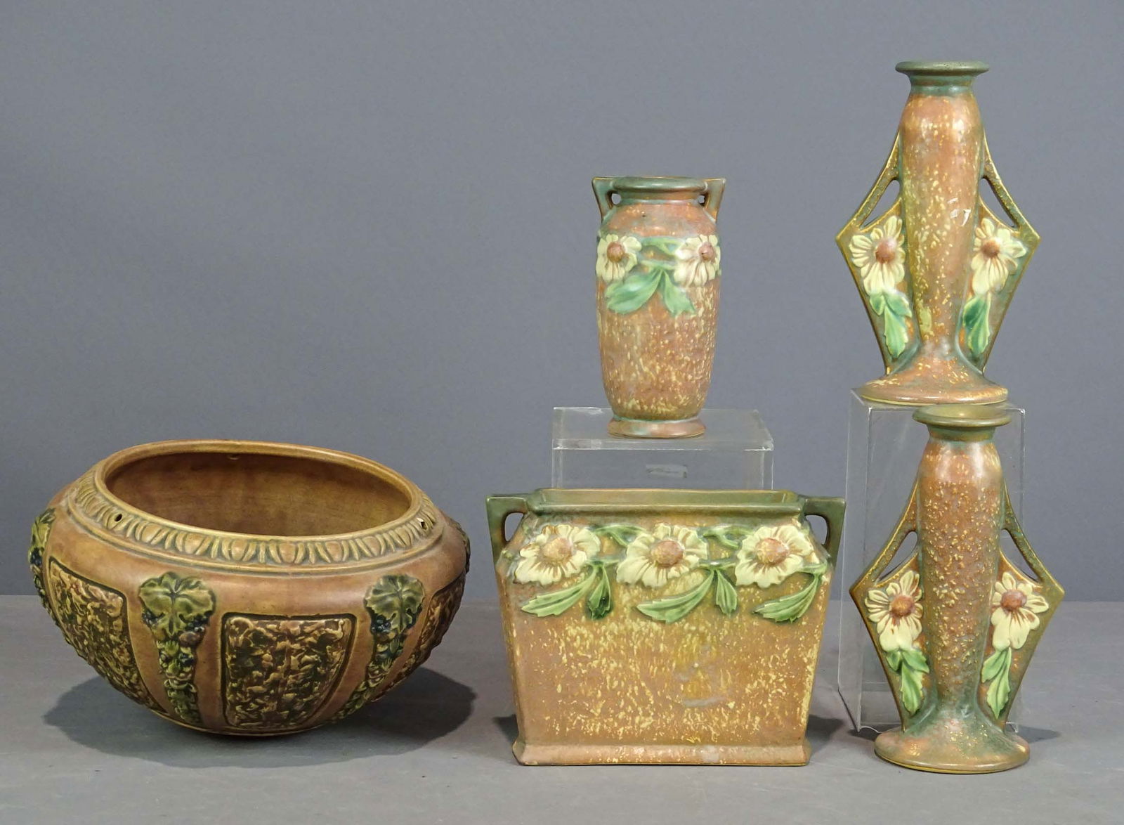 Roseville Lot: Roseville lot including pair of candlesticks (8 1/2" Ht.), vase, (2) planters (largest 9" D., 5 1/2" Ht.). Good condition.