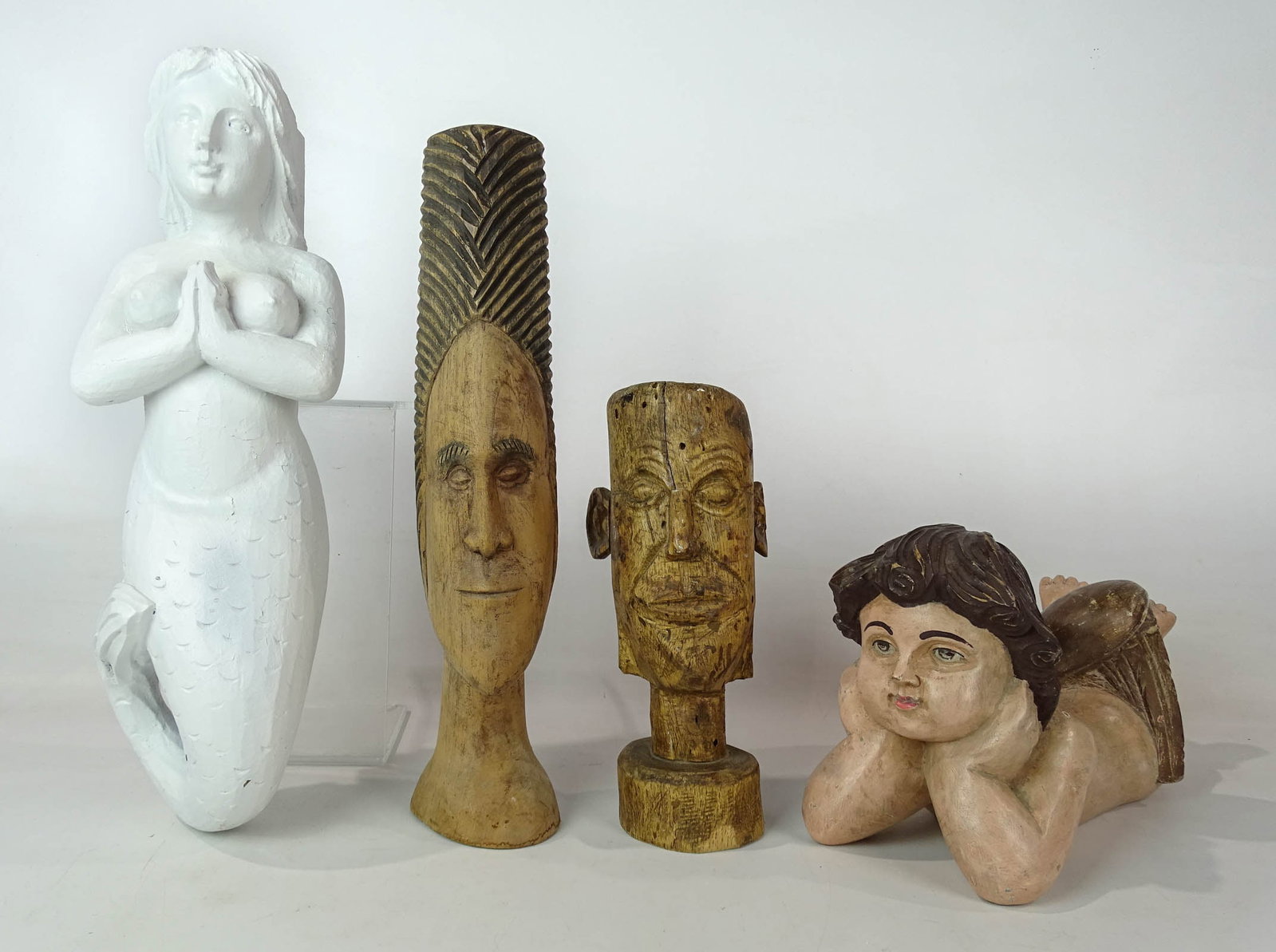 Lot of Carvings: Lot (4) folk art wooden carvings including head (11" Ht.), mast head (17 1/2" L.), head (17" L.), Angel (13" L.).