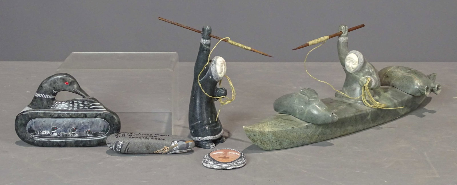 Carved and Polished Stone Lot: Carved and polished stone lot including: wall plaque, seabirds, 5 1/2" x 4", signed "Joma", hunter with bone face and spear (6 1/2" Ht.), Kayak and hunter with seals (16 1/32" x 5 1/2" Ht.), (2) paint