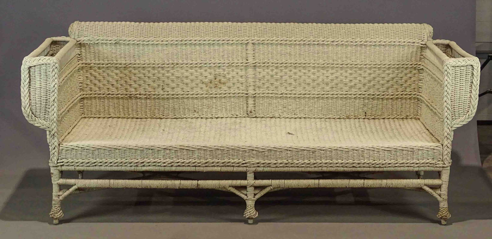 Wicker Couch: Large wicker couch with magazine racks on arm rests. 7' 6" W., 36" D., 37" Ht., 16" seat Ht..