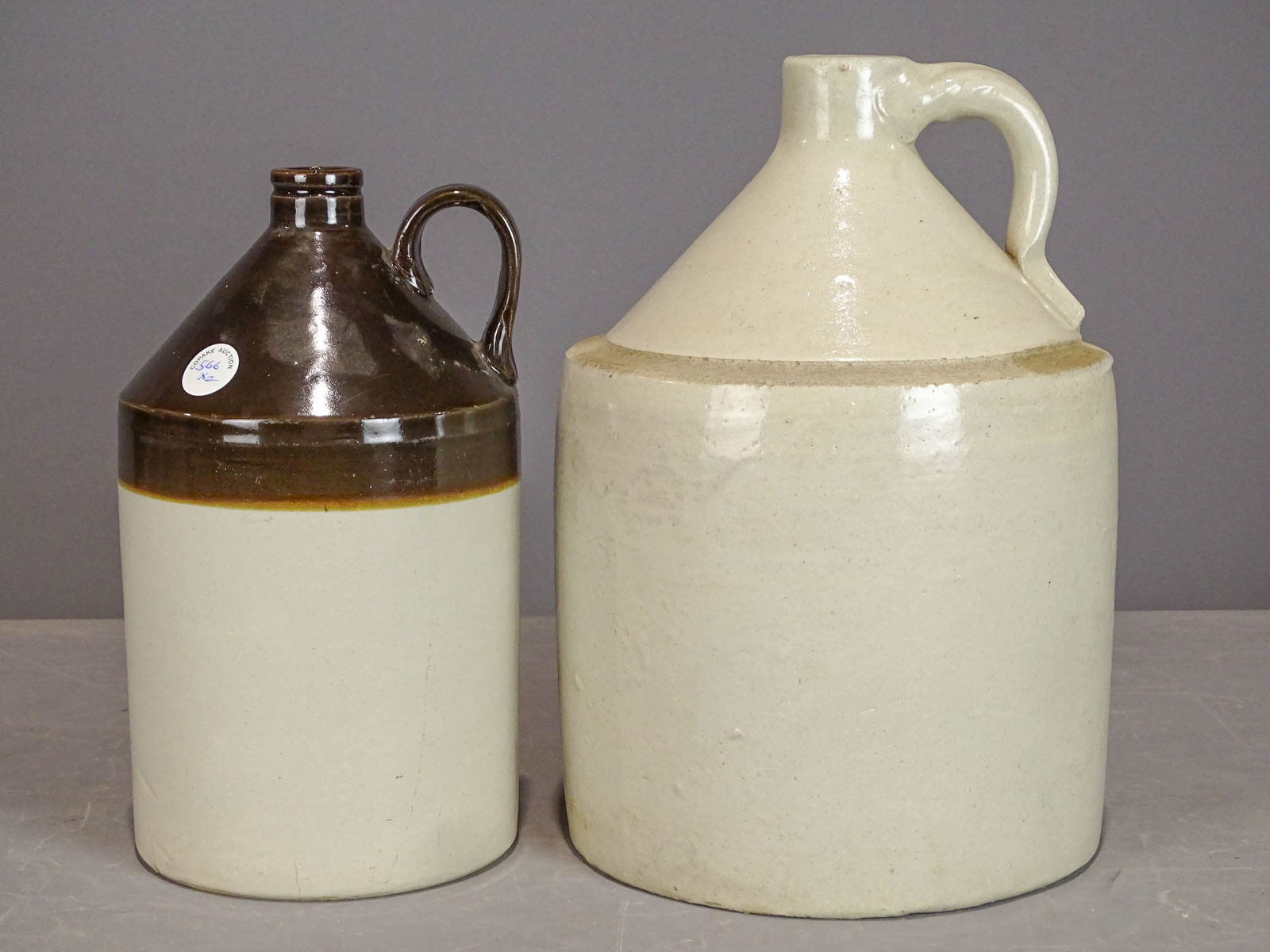 Stoneware Lot: Lot (2) stoneware jugs. Largest 13 1/2" Ht..