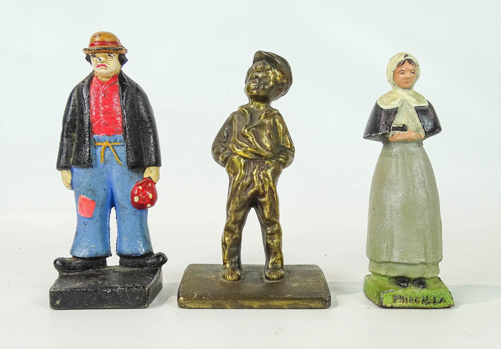 Misc. Lot: Lot (3) cast iron doorstops including: Priscilla (6 1/2" Ht.), Bradley and Hubbard Tom Sawyer doorstop (C. 1925, 6 3/4" Ht.), Hobo doorstop (7" Ht.).