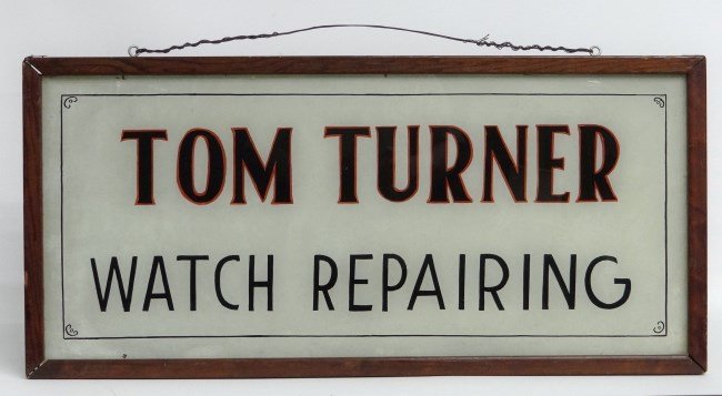 Trade Sign: C. 1900's reverse painted "Tom Turner Watch Repairing" sign. 18" x 37 1/2". Small chip above letter R near frame.