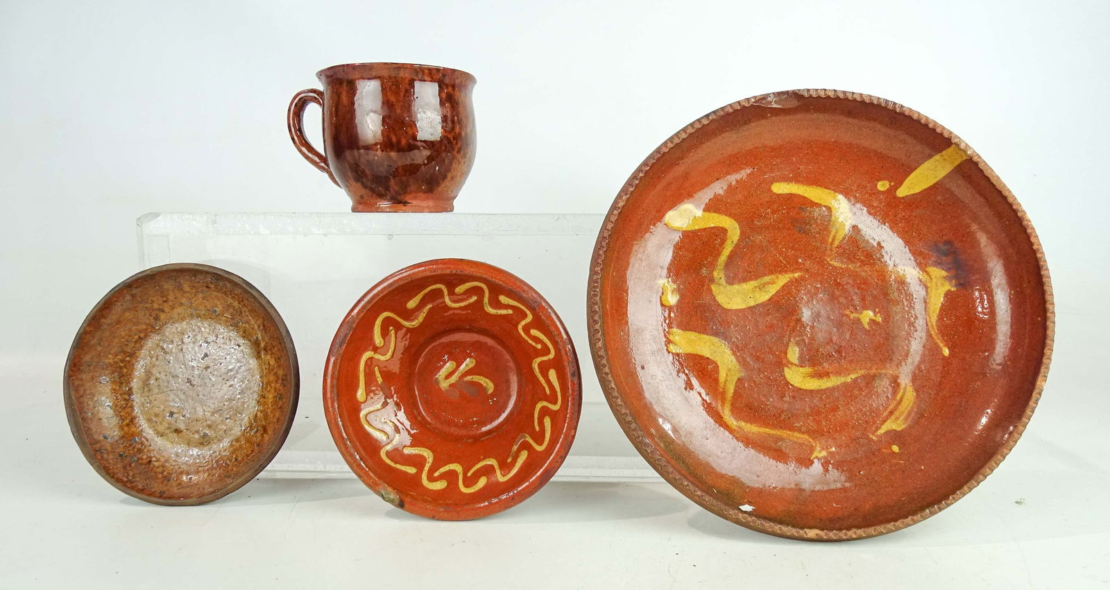 Redware Lot: Lot (4) pieces of early redware including cup, (2) dishes and slip decorated plate (9" D.).