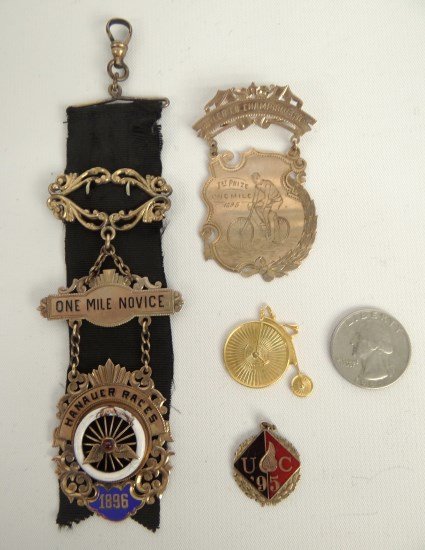 Gold Bicycle Medals: Two gold medals/fob including "Butler Co. Championship 1st Prize One Mile 1895" and "One Mile Novice Hanauer Races 1896", along with 10 Karat High Wheel pendant and 10 Karat "UC '95" pendant. Good con