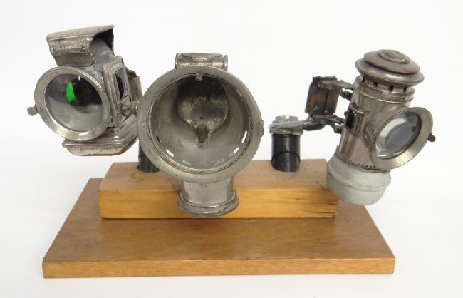Bicycle Carbide Lamps: Lot (3) bicycle carbide lamps: Powell & Hanmer "Daylite", Herm Reimann "Pfadfinder", unmarked example (parts only). All lamps have adjsutable rear brackets. Good condition except for unmarked example.