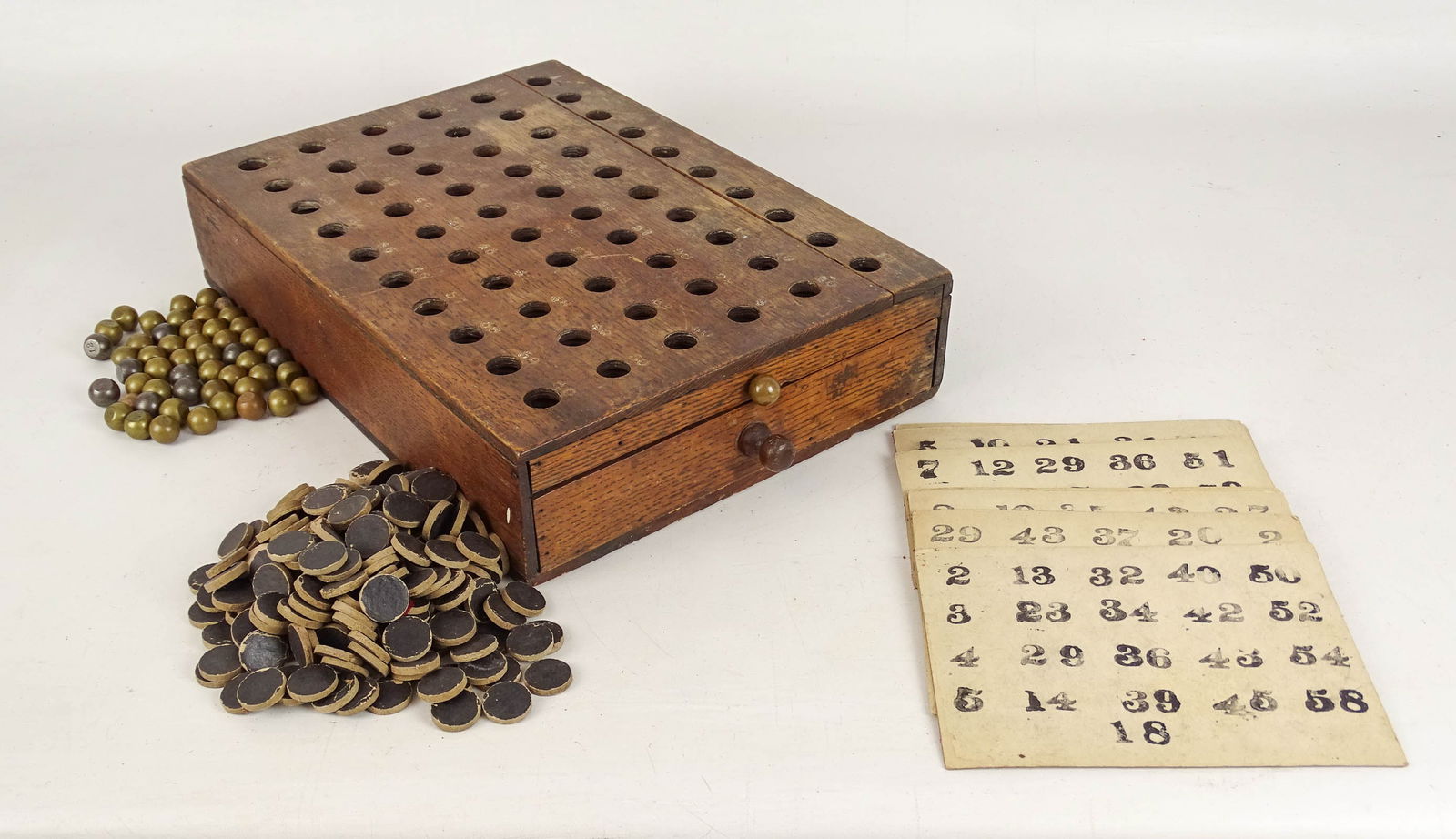 Early Bingo Game: Early oak case Bingo game with drawer, cards, weighted and cardboard pieces. 10" x 14" x 3".