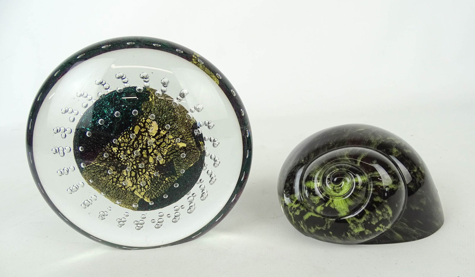 (2) Art Glass Paperweights: Art glass paperweights (2): Robert Eickholt disc paperwight (c. 1993, 5" dia.), Daum France green glass snail shell (2" ht., 4"dia.).