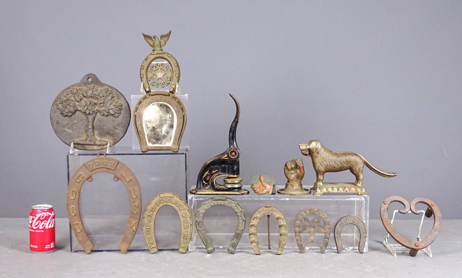 Cast Metal Collection: Misc. pieces (14), including: heart shaped trivet, "Thumbs up" paper weight, bronze clenched fist, dog nutcracker (L.A. Althoft MFG Co.), Tree Form Fire Insurance marked plaque, (8) decorated advertis