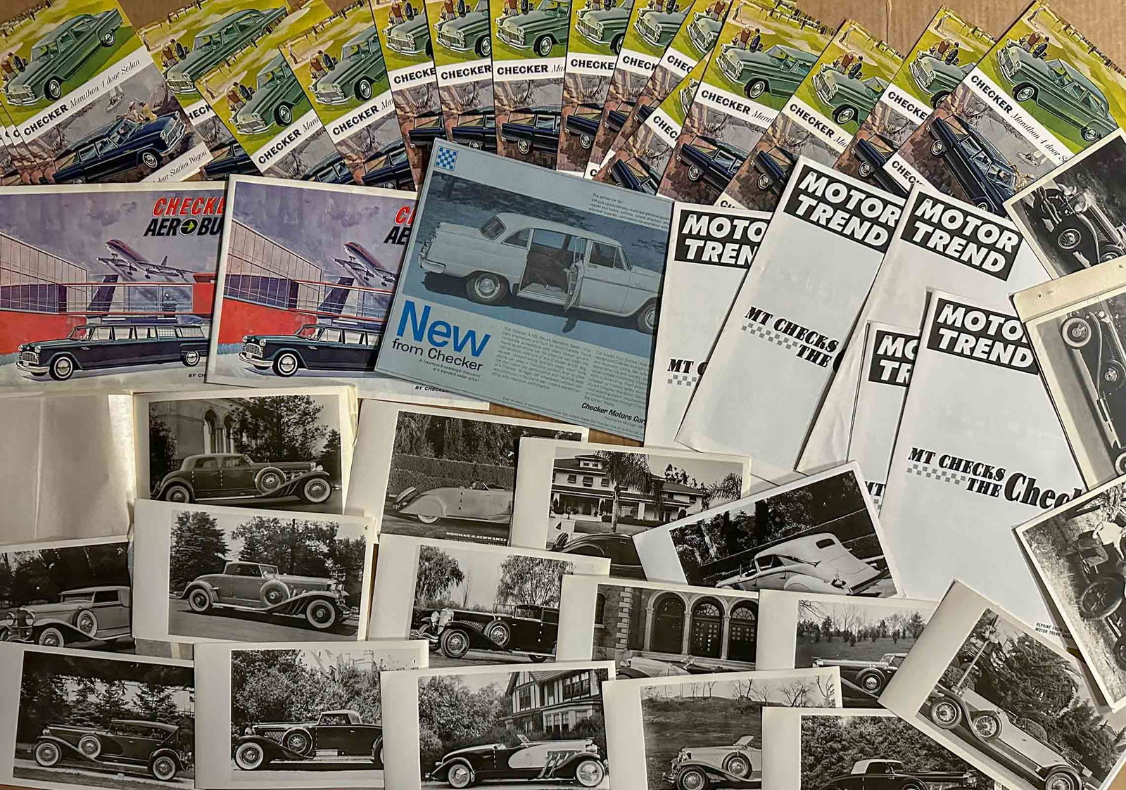 Early Brochures: Teens to 1960's brochures and photos - twenty five brochures, seventeen Checker postcards, group of Duesenburg photos.